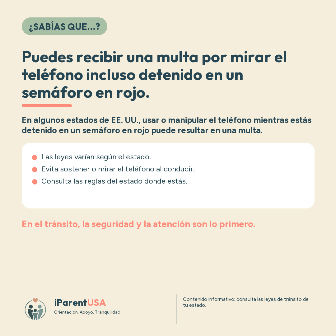 Conductor con el celular en la mano detenido en un semáforo en rojo